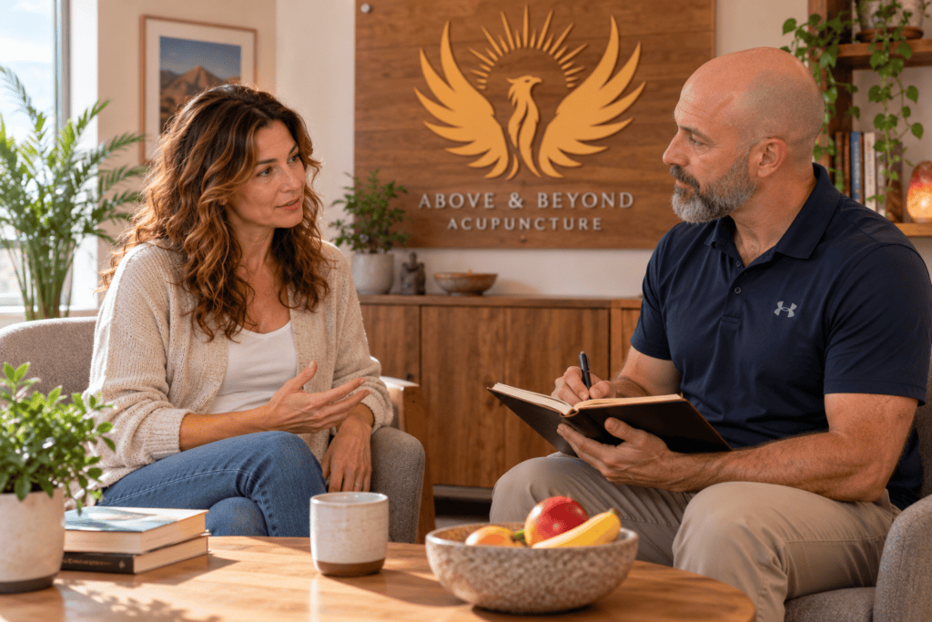 Acupuncturist discussing diet and digestive symptoms with a patient during a Chinese medicine consultation.