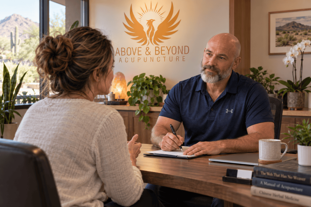 Acupuncturist discussing a patient’s symptoms during a Traditional Chinese Medicine consultation at Above & Beyond Acupuncture.