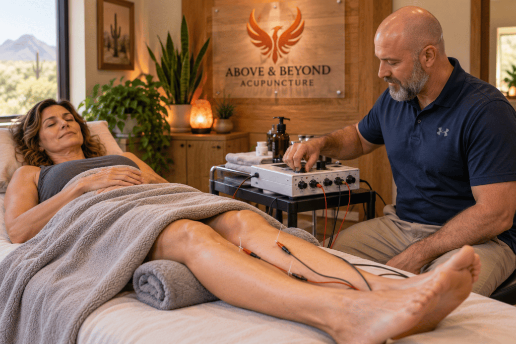 Relaxed woman receiving electroacupuncture while her acupuncturist adjusts the stimulation level.