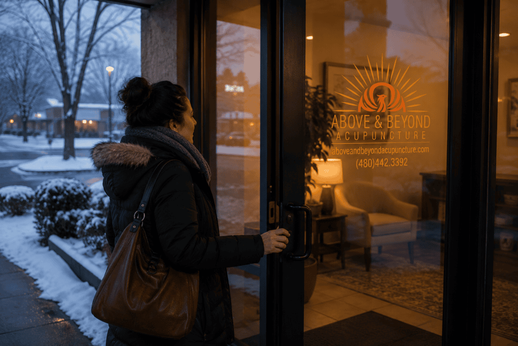 Person arriving at a warm, welcoming acupuncture clinic on a cold winter day.