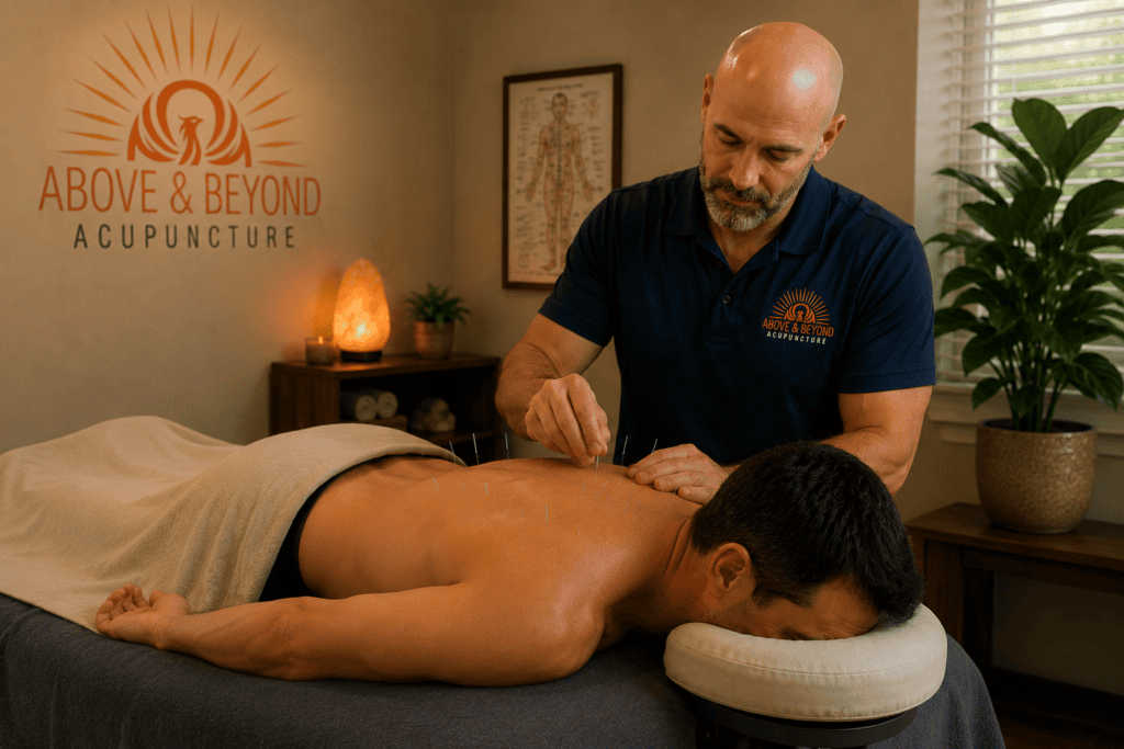 Man receiving acupuncture while lying face down on a treatment table at Above and Beyond Acupuncture.