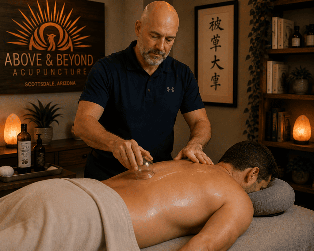 Licensed acupuncturist performing running cupping using virgin olive oil on a patient's back to break up fascia adhesions.