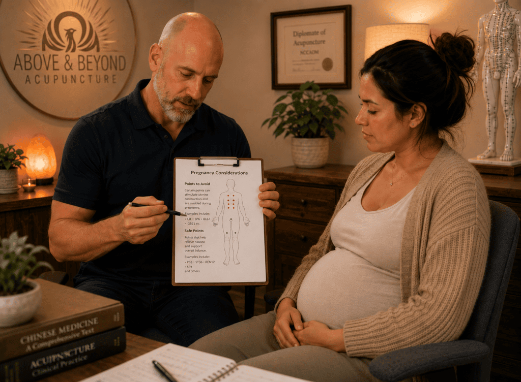 Licensed acupuncturist reviewing a pregnant patient’s chart, reflecting the training required to select pregnancy-safe points.