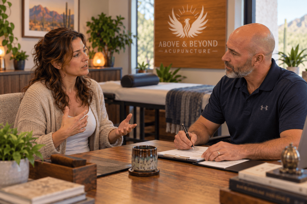 Woman discussing her recurring acid reflux symptoms with an acupuncturist during a consultation.